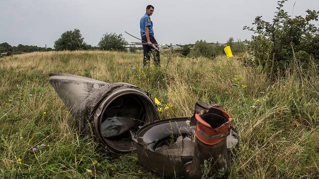 Policial trabalha na busca por corpos no local onde o avião da Malaysia Airlines foi abatido, em Grabovka, Ucrânia