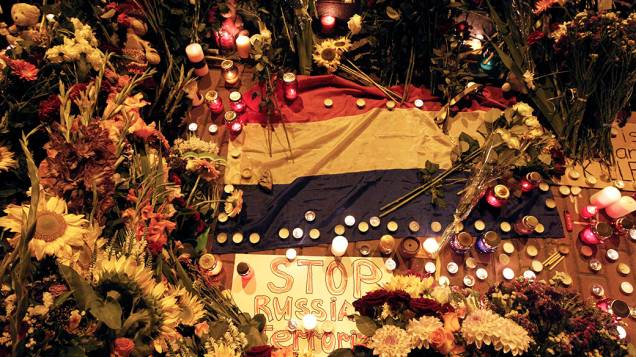 Pessoas prestam homenagens em frente à Embaixada da Holanda em Kiev para as vítimas do voo MH17 da Malaysia Airlines que foi abatido por um míssil