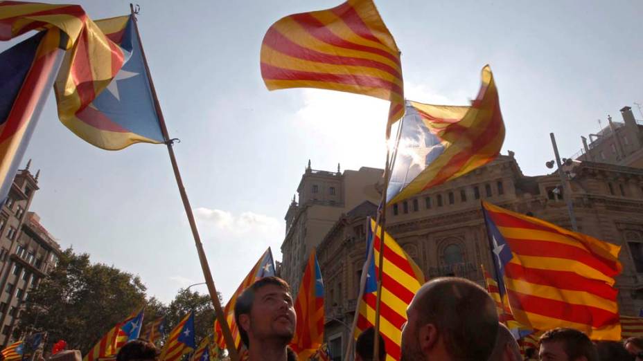 Os manifestantes nacionalistas catalães com bandeiras durante Dia Nacional da Catalunha em Barcelona