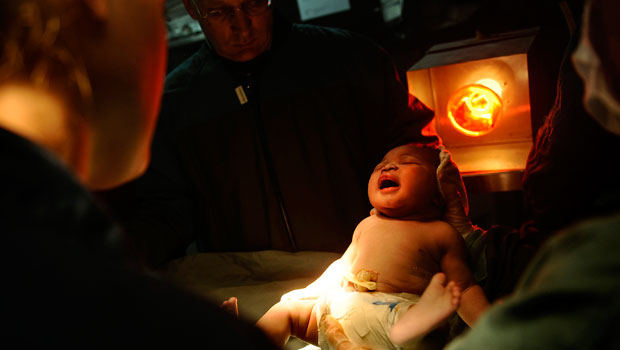 Recém nascido é aquecido por uma lâmpada a bordo do navio americano USS Bataan. Além dos militares, várias missões de médicos americanos foram ao Haiti