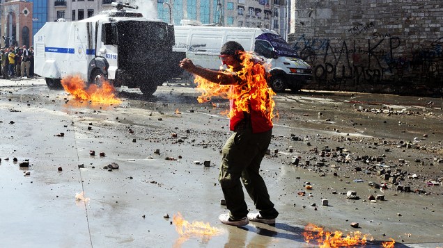 Manifestante se queima ao manipular um coquetel molotov durante confronto na praça Taksim, na Turquia, nesta terça (11)