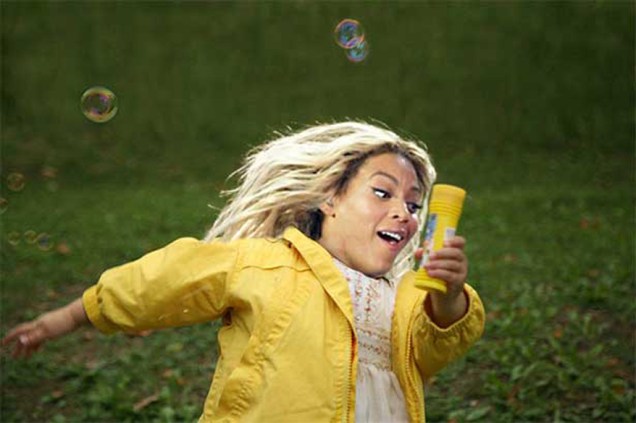 A pequena Beyoncé saltita feliz entre bolhas de sabão