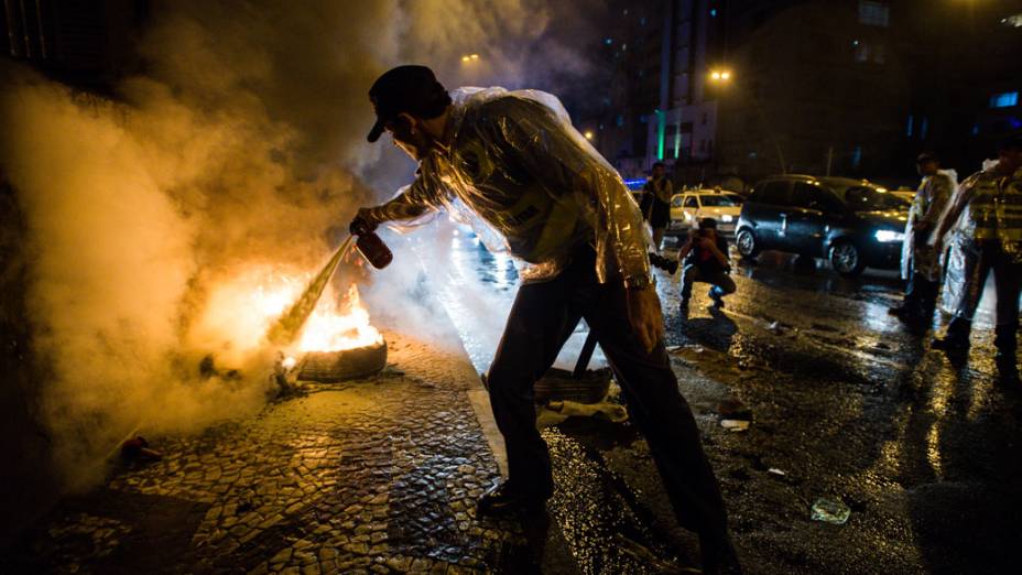 Policiais combatendo fogo deixado por manifestantes, durante ato contra o aumento da passagem