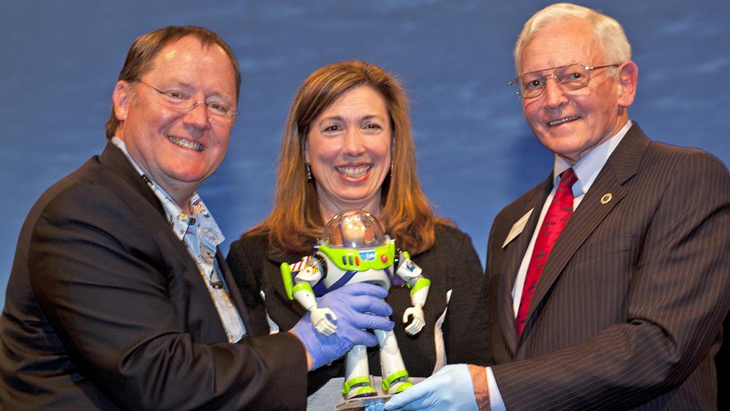 Boneco "Buzz Lightyear" do filme "Toy Story" doado à NASA, entre John Lasseter, da Pixar; a vice-diretora da Nasa, Lori Garver; e o diretor do Museu do Ar e do Espaço do Instituto Smithsonian, Jack Dailey