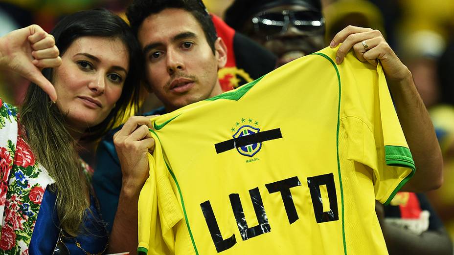 Torcedores seguram uma camisa da seleção brasileira com a palavra Luto", após o jogo contra a Holanda no Mané Garrincha, em Brasília