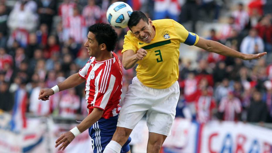 Marcelo Estigarribia, do Paraguai, e Lúcio disputam bola durante jogo das quartas de final da Copa América