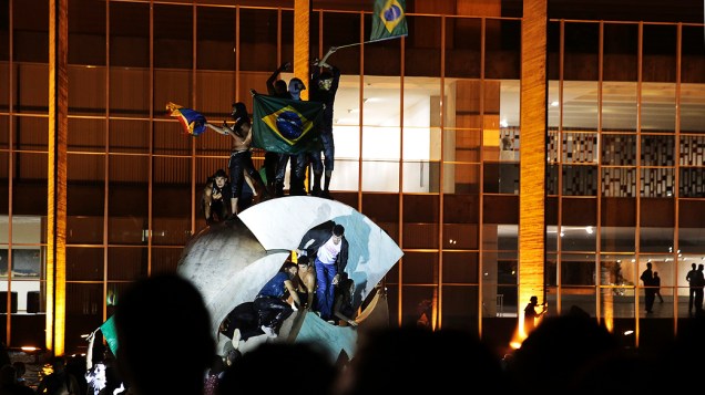 Brasília - Manifestantes sobem em cima da escultura Meteoro, em frente ao Palácio do Itamaraty
