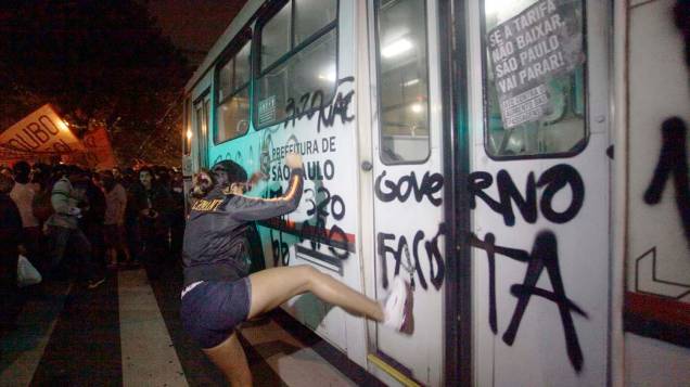 Manifestante chuta um ônibus no protesto contra o aumento da passagem de ônibus