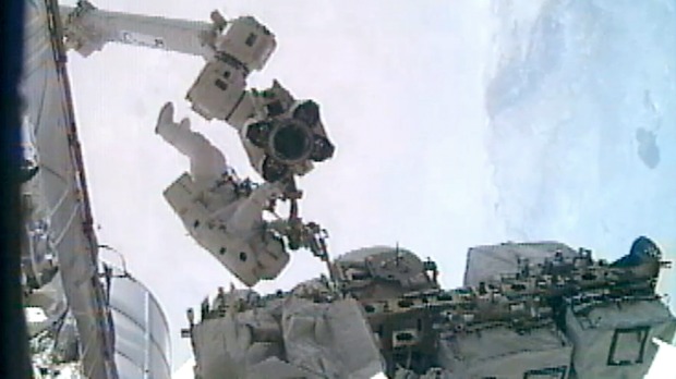 Astronauta Ronald Garan instala uma peça no Canada Arm 2 enquanto Michael Fossum faz reparos na Estação Espacial Internacional (ISS)