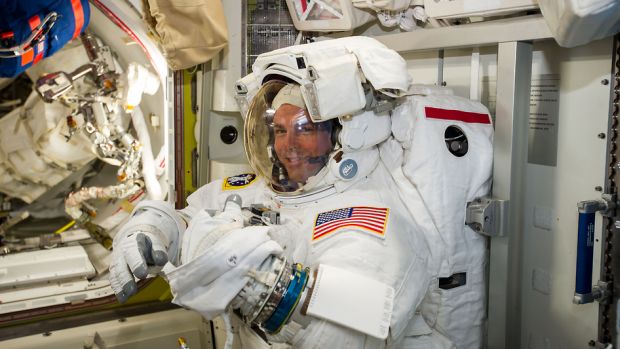 O astronauta Reid Wiseman checa seu traje para a caminhada espacial