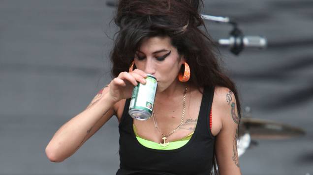 Amy Winehouse bebe cerveja durante apresentação no Virgin Festival. A cantora inglesa tinha problemas com bebidas alcóolicas