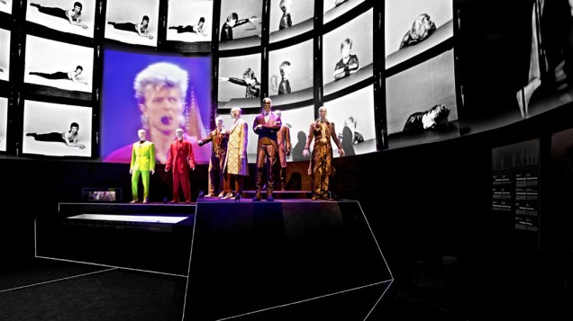 Grande sala da exposição no MIS reúne figurinos de diversas fases da carreira de David Bowie enquanto clipes passam ao fundo