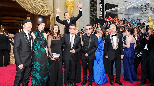 O ator Benedict Cumberbatch pula para aparecer na foto com os membros da banda U2 durante cerimônia do Oscar 2014
