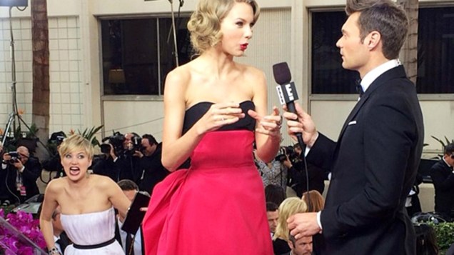 Jennifer Lawrence faz careta e aparece na transmissão de uma entrevista da cantora Taylor Swift na chegada para a cerimônia do Globo de Ouro 2014