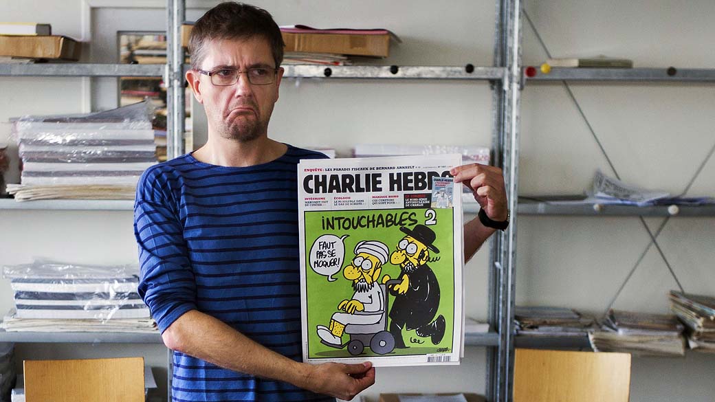 Editor do satírico 'Charlie Hebdo' conhecido apenas como Charb exibe a última edição da revista, que traz na capa uma charge sobre o Islã. A França anunciou que fechará temporariamente embaixadas e escolas em 20 países após a publicação