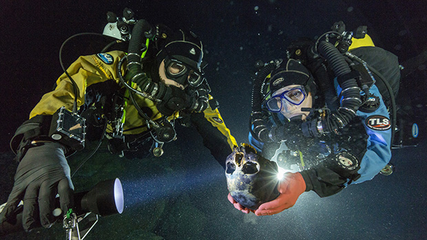 Os mergulhadores Alberto Nava e  Susan Bird transportam o crânio encontrado na caverna de Hoyo Negro, no México, até uma plataforma giratória para que ele fosse fotografado