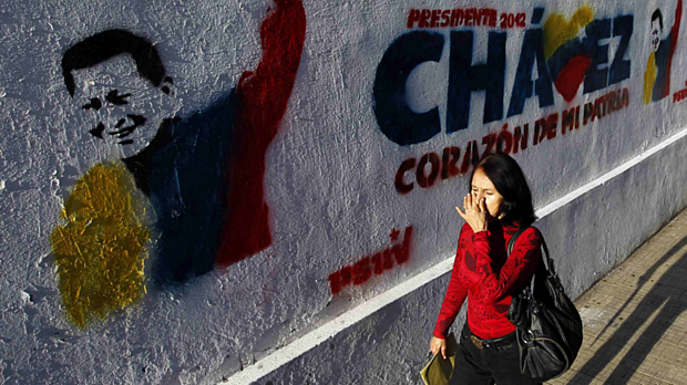 Mulher passa diante de propaganda eleitoral de Hugo Chávez