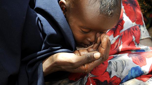 Mãe dá água ao filho no campo de refugiados de Dadaab, no Quênia: situação da África Subsaariana preocupa a OMS