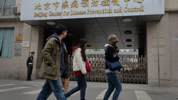 Pedestres caminham em frente ao Centro para Controle e Prevenção de Doenças em Pequim: nova cepa da gripe aviária já matou 18 pessoas na China
