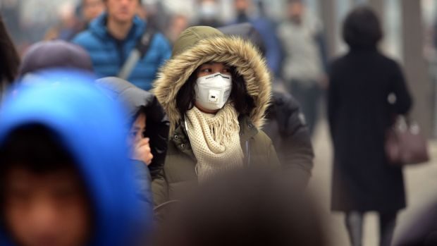 China: Pedestre usa máscara para se proteger contra a poluição em Pequim