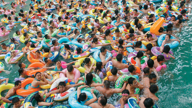 UM LUGARZINHO, POR FAVOR - Moradores da cidade de Suining, na China, disputam espaço para se refrescar em piscina pública em dia de calor intenso: falta lugar até dentro d’água