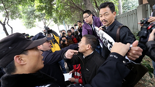 Policial tenta impedir manifestante de protestar por mais liberdade de imprensa na cidade de Guangzhou, sul da China