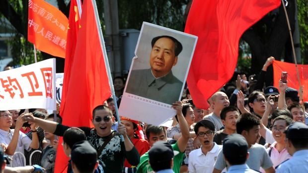 Chineses carregam retrato de Mao Tse-tung em manifestação contra o Japão em Pequim