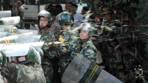 Policiais chineses são atingidos por manifestantes em frente à embaixada do Japão em Pequim