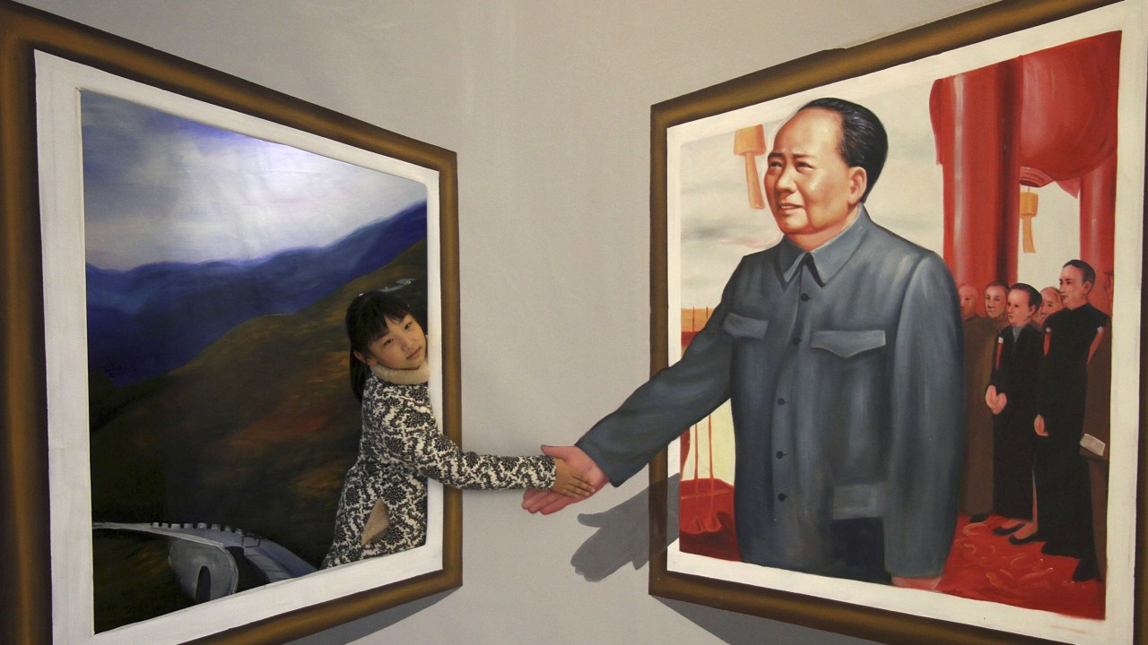 Chinesa posa para foto diante de pintura em 3D do ditador Mao Tsé-tung