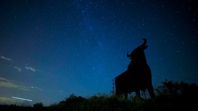 <p>Chuva de meteoros (Perseidas) vista acima da silhueta de um outdoor em forma de touro, em uma estrada, do Vilarejo de Salvanes, na Espanha</p>