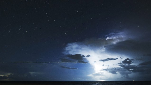 <p>Avião sobrevoa o mar em meio a uma tempestade no último dia da chuva anual de meteoros Perseidas, perto de Cancún, no México</p>