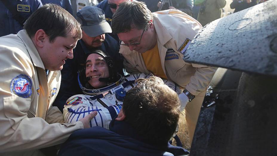 <p>Equipe espacial russa presta assistência ao astronauta Chris Cassidy após pouso da cápsula espacial Soyuz TMA-08M cerca de 146 km a sudeste da cidade de Zhezkazgan, no Cazaquistão</p>