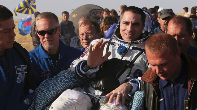 <p>Equipe espacial russa presta assistência ao astronauta Chris Cassidy após pouso da cápsula espacial Soyuz TMA-08M cerca de 146 km a sudeste da cidade de Zhezkazgan, no Cazaquistão</p>