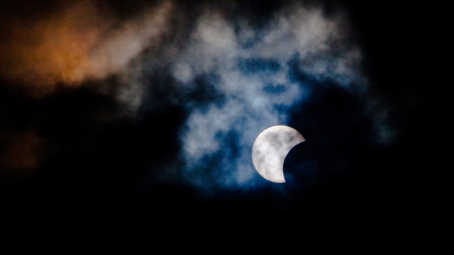 <p>Eclipse solar híbrido é observado através das nuvens da ilha canária de Tenerife, na Espanha</p>