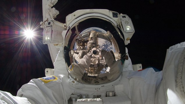 <p>O astronauta Aki Hoshide tirou uma selfie durante os reparos na Estação Espacial Internacional. É possível ver o braço mecânico em seu visor, assim como a Terra, e o Sol por trás dele</p>