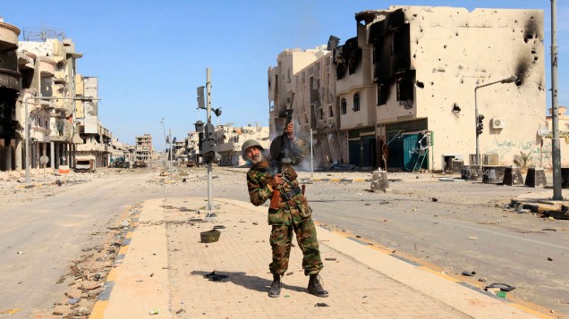 Homem comemora a captura e morte de Kadafi, na cidade de Sirte, Líbia