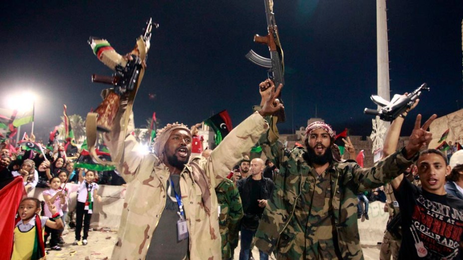 Rebeldes líbios comemoram a morte de Kadafi na Praça dos Mártires, em Trípoli