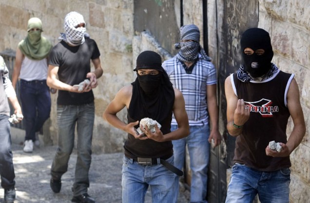 Palestinos se armam com pedras para enfrentar soldados israelenses, em Jerusalém.