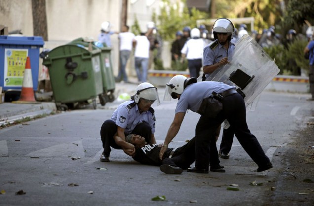 Policiais socorrem manifestante palestino que se feriu durante protesto.