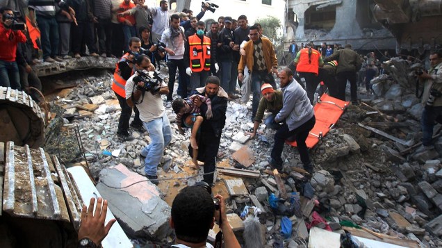 Homem carrega corpo de criança morta durante ataque aéreo na Cidade de Gaza