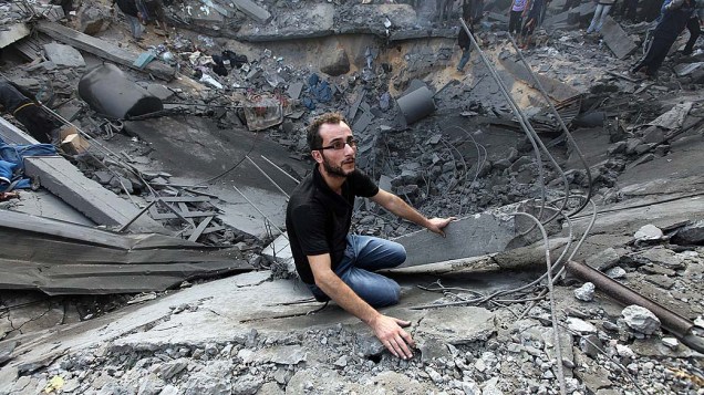 Palestino nos escombros da sua casa destruída por ataque aéreo, na Cidade de Gaza
