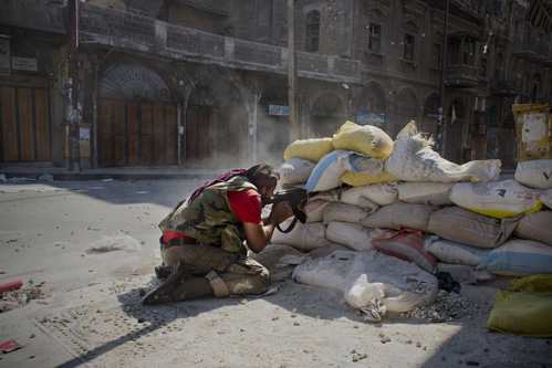 Rebelde abre fogo em combate contra soldados do Exército sírio, em um beco no centro velho de Alepo