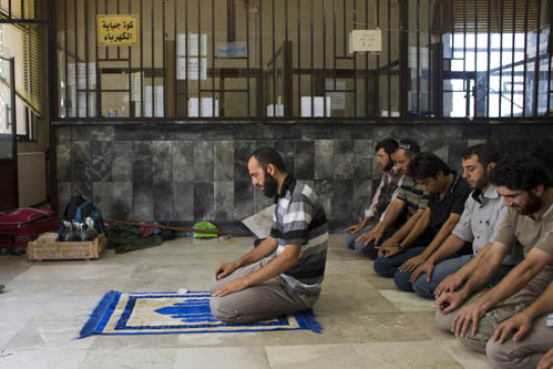 Hajji Mari, líder da Brigada da União, reza com seus comandados antes de ir para a linha de frente em Alepo