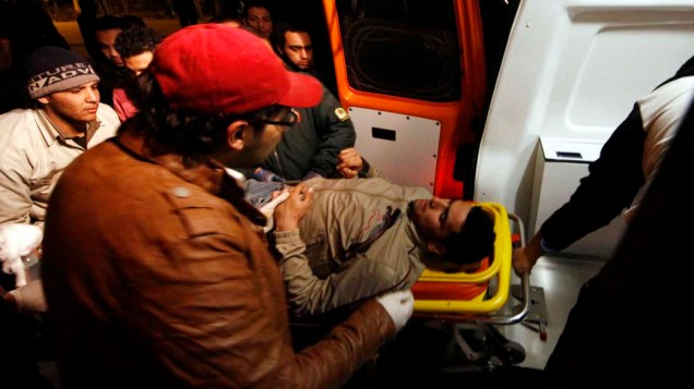 Após confusão, homem é levado para a ambulância, no Cairo