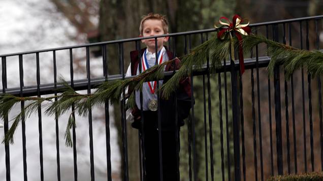Menino espera para entrar no local, onde a família do garoto Jack Pinto, de seis anos, morto no ataque à escola primária Sandy Hook,  realiza seu funeral, em Newtown, Connecticut