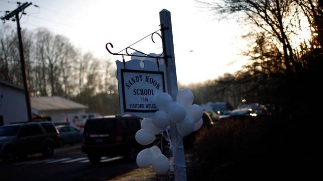 Balões pendurados na placa da escola Sandy Hook, onde aconteceu o tiroteio que matou 27 pessoas nessa sexta, em Newtown