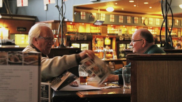 <p>Os amigos Bill Marshall, 71, e David Forbes, 70, acostumam-se aos novoso tempos em Londres: no pub, o peixe é verde</p>
