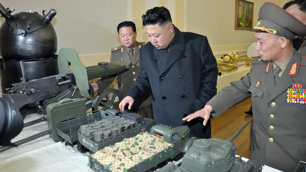 O líder norte-coreano Kim Jong Un observa miniaturas de equipamento militar