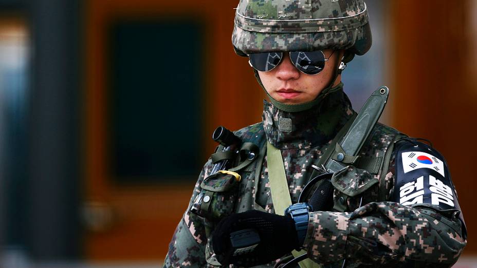 Soldado sul-coreano checa o horário de chegada de veículos trazendo trabalhadores do complexo industrial de Kaesong, localizado na Coreia do Norte, no posto sul-coreano de fronteira em Paju