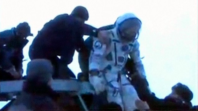 O astronauta Kevin Ford recebendo ajuda para sair da cápsula russa Soyuz, após aterissagem no Cazaquistão